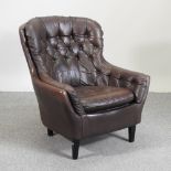 A 1960's brown leather button back armchair