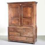 An 18th century oak cabinet, enclosed by a pair of panelled doors, with drawers below,