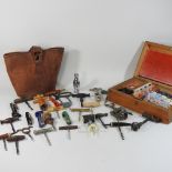 A collection of thirty-six assorted novelty corkscrews, together with a bag and a games compendium,