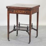 An Edwardian rosewood and inlaid envelope card table,