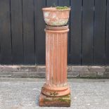 A terracotta garden pot, on a fluted terracotta column,