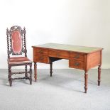 An Edwardian walnut writing desk, with a green inset writing surface, on turned legs,