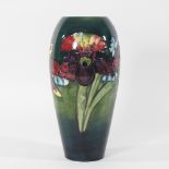 An early 20th century Moorcroft pottery vase, of slender shape, decorated in the Iris pattern,