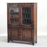 A reproduction carved oak cabinet bookcase,
