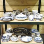 Two shelves of mainly early 20th century Staffordshire blue and white table wares,