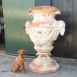 A large and impressive white painted cast iron garden urn, of pedestal shape,