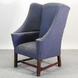 A blue upholstered wing armchair, on square legs, together with a cream painted standard lamp,