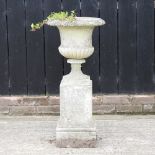A reconstituted stone garden urn, on a pedestal base,