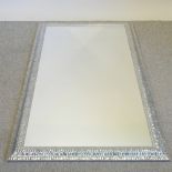 A large silver painted wall mirror,