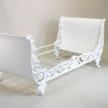 An early 20th century French white painted cast iron sleigh bed, with ornate scrolled decoration,