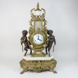 An ornate French gilt figural mantel clock, on a marble base,