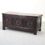 An 18th century carved oak panelled coffer, with a hinged lid,