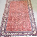 A Persian woollen carpet, with all over foliate designs, on a red ground,