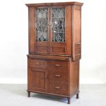 An early 20th century Arts and Crafts glazed oak cabinet,