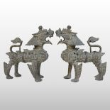 A pair of late 19th century weathered bronze models of Tibetan Dogs of Fo, each shown standing,