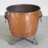 A copper coal bin, on paw feet,