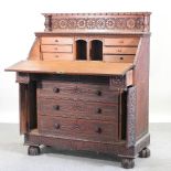 An unusual early 20th century continental heavily carved oak bureau, on turned feet,