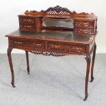 A late Victorian mahogany writing desk, with a mirrored back, containing drawers,