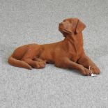 A rusted metal model of a resting gun dog,