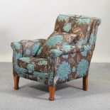 A recently upholstered Edwardian blue and brown floral upholstered armchair,