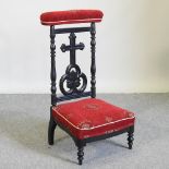 A Victorian ebonised and red upholstered prie dieu chair