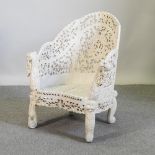 A Burmese carved hardwood and white painted tub shaped armchair