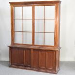 An early 20th century oak gun cabinet, with a glazed upper section,