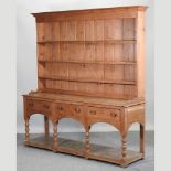 An antique pine dresser, the base containing three drawers,