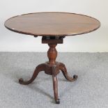 An early 20th century walnut tripod table,