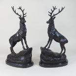 A pair of modern bronze models of stags, each on a marble base,