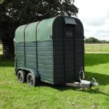 A green light weight pony trailer, with a metal floor and twin axle,