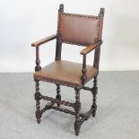 A 17th century style oak and leather upholstered high back open armchair