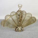 An ornate brass adjustable fan fire screen, of peacock design,