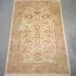 A modern woollen rug, with all over foliate design, on a cream ground,
