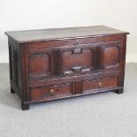An 18th century oak mule chest, with a hinged lid and containing two short drawers below,