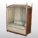 A 19th century Louis XV style carved walnut lovers' chair, having a canopy top, of domed shape,