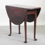 A George III mahogany drop leaf dining table, on pad feet,
