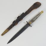 A World War II commando knife, No 2, the blade inscribed SS fighting knife, in a leather scabbard,