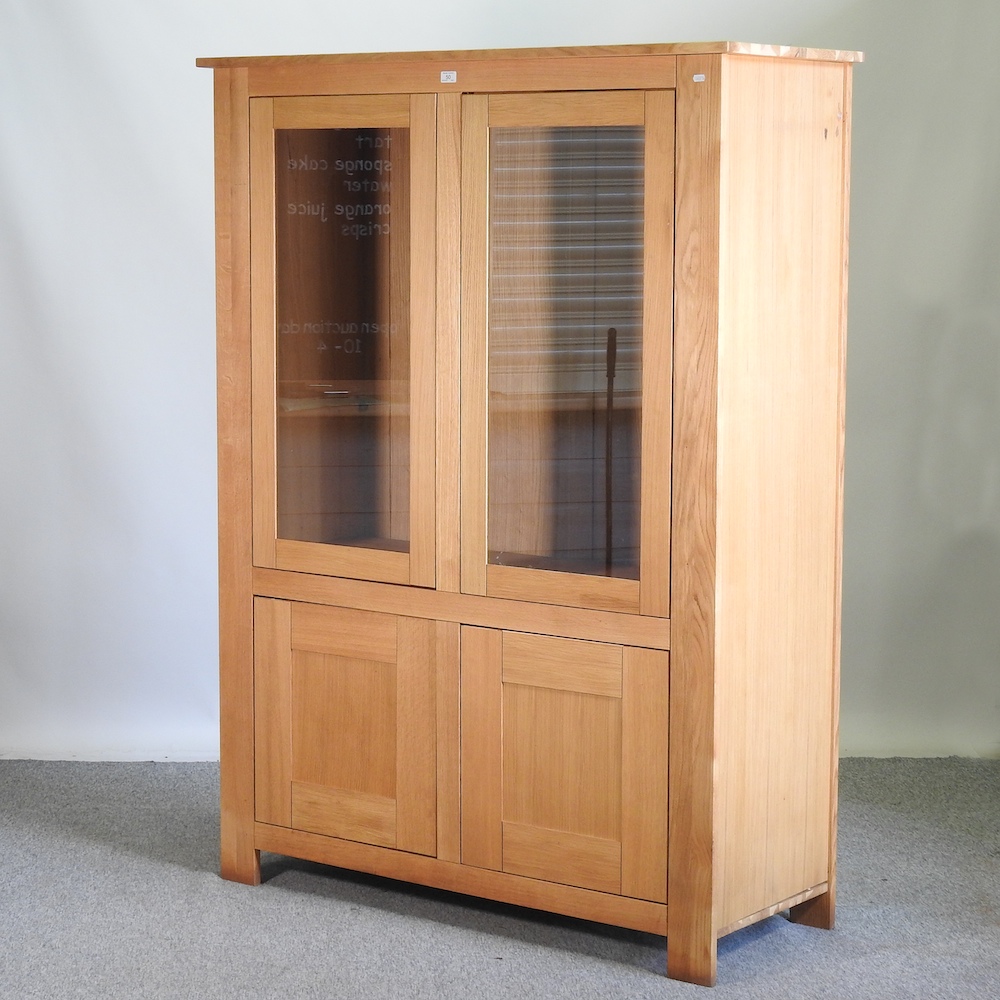 A modern light oak glazed cabinet,