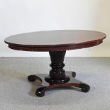 A mahogany pedestal coffee table, with an oval top,