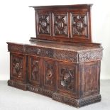 A 19th century oak Jacobean style carved oak sideboard, of inverted breakfront form,
