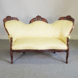 A Victorian carved and yellow upholstered children's show frame sofa, of small proportions,