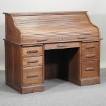 A mid 20th century light oak tambour top pedestal desk,