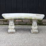 A reconstituted stone curved garden bench, with supports in the form of squirrels,