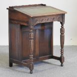 A reproduction carved oak davenport, with a green inset writing surface,