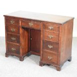 An early 20th century mahogany kneehole desk, on bracket feet,