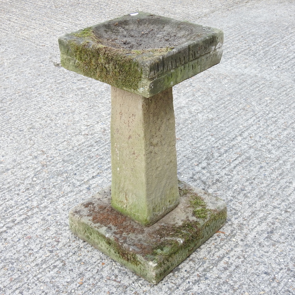 A reconstituted stone bird bath, with a square top,