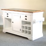 A modern white painted kitchen island, with a granite top,