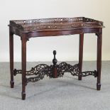 A reproduction mahogany silver table, with fret carved gallery and undertier,