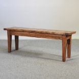 A rustic pine bench, on square tapered legs,